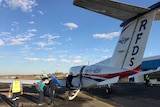 A Royal Flying Doctor Service plane sitting on the tarmac as passengers board