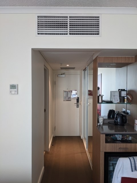 Rikki-Lee Romeyn and wife Jill Huang in COVID-19 hotel quarantine room showing air conditioning vent
