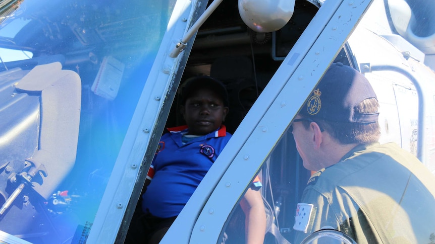 A Tiwi Islands child talks to a navy officer from the pilot's seat of a Navy Seahawk helicopter