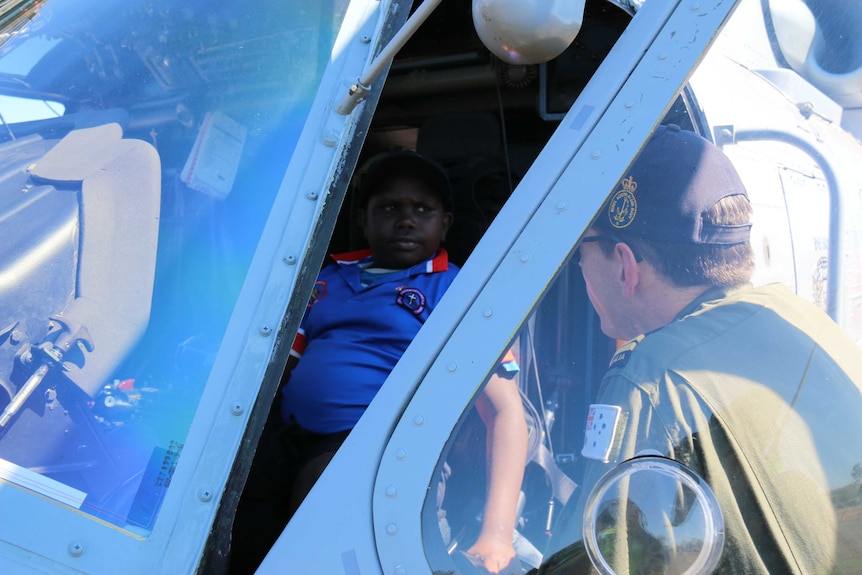 A Tiwi Islands child talks to a navy officer from the pilot's seat of a Navy Seahawk helicopter