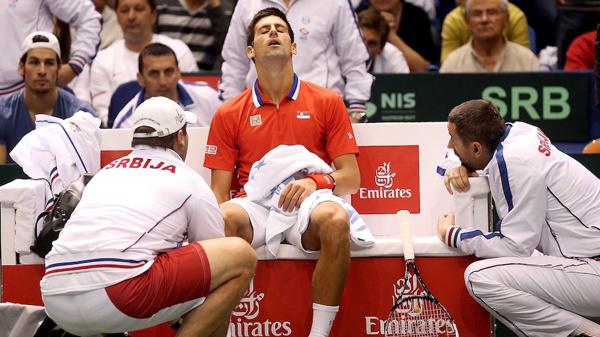 Novak Djokovic receives treatment on his injured ankle during Serbia's Davis Cup tie with the US.