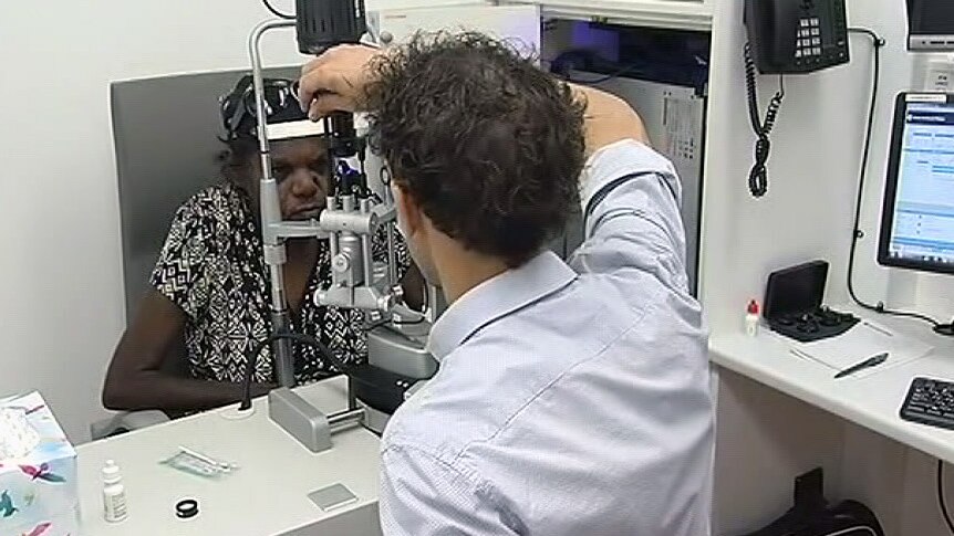 An ophthalmologist examines an indigenous woman's eyes.