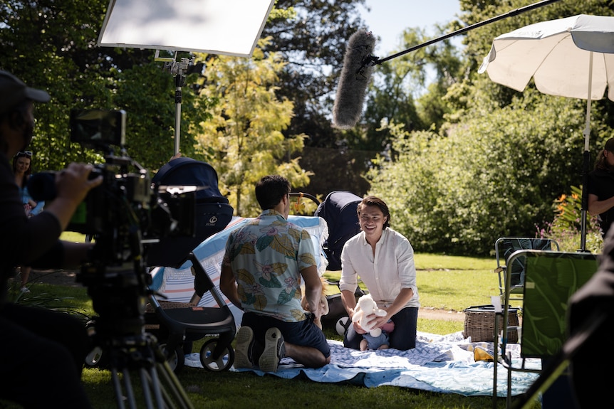 A behind-the-scenes photograph of a scene being filmed at a park.