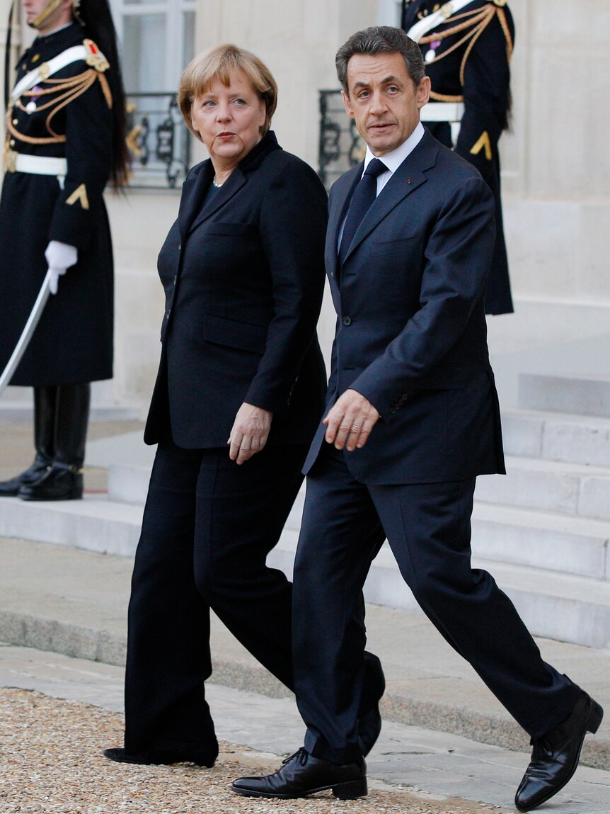 France's president Nicolas Sarkozy escorts German chancellor Angela Merkel following a joint news conference