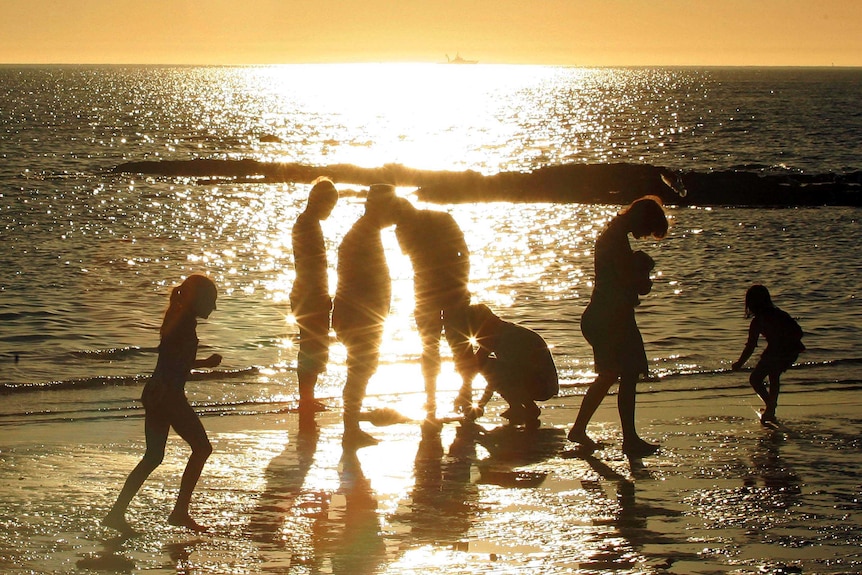 People walk on Brighton Beach in Melbourne