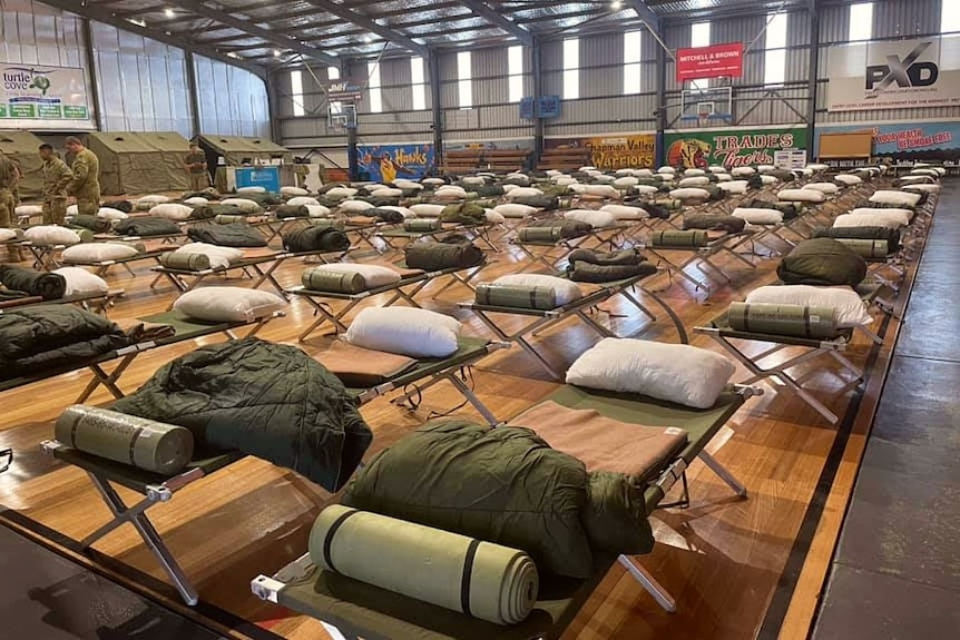 A wide shot of Army camp beds set up inside a basketball stadium in Geraldton.