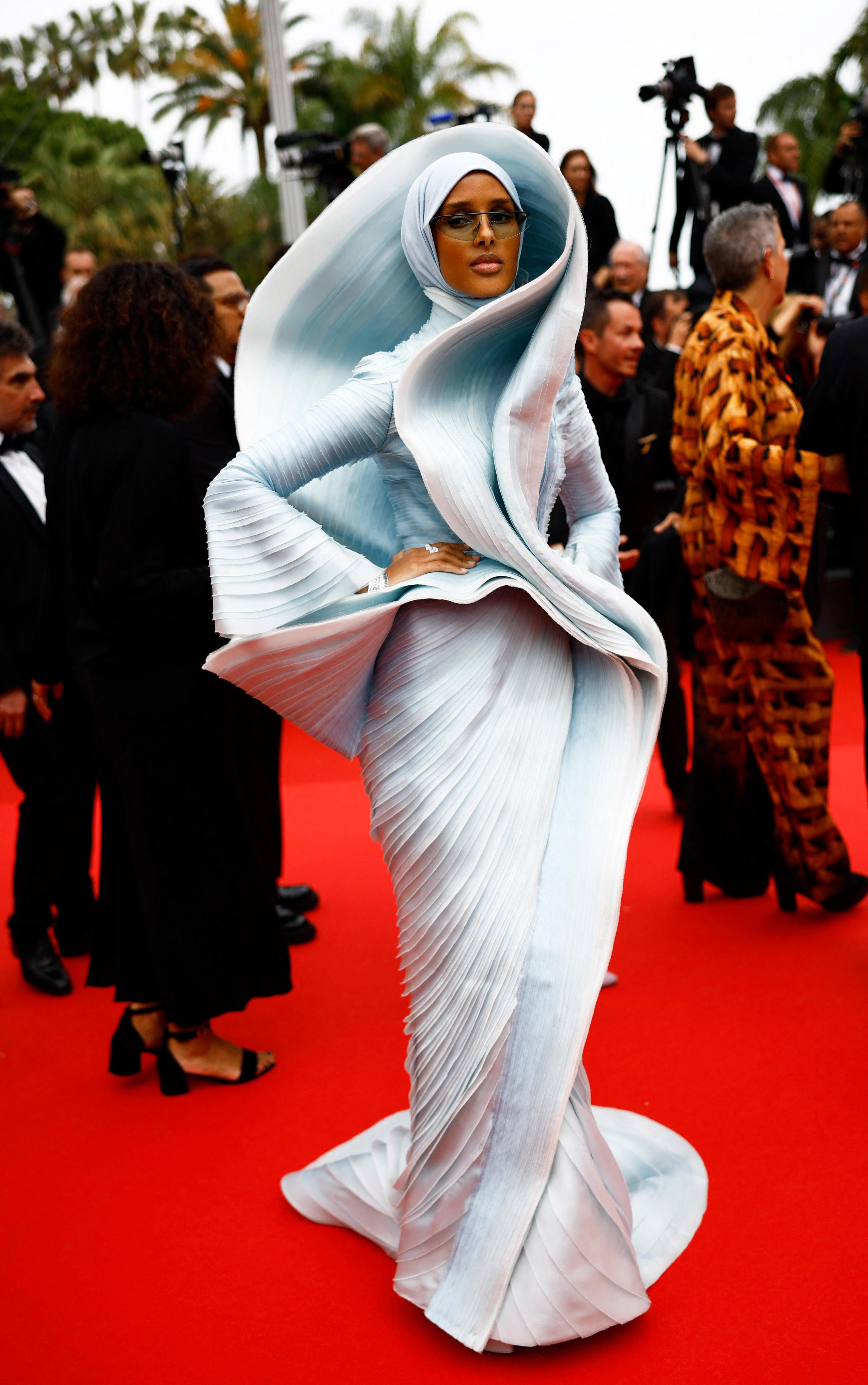 Rawdah Mohamed wearing a pale blue dress with a wave-like hood with structural detail around the bodice and waist
