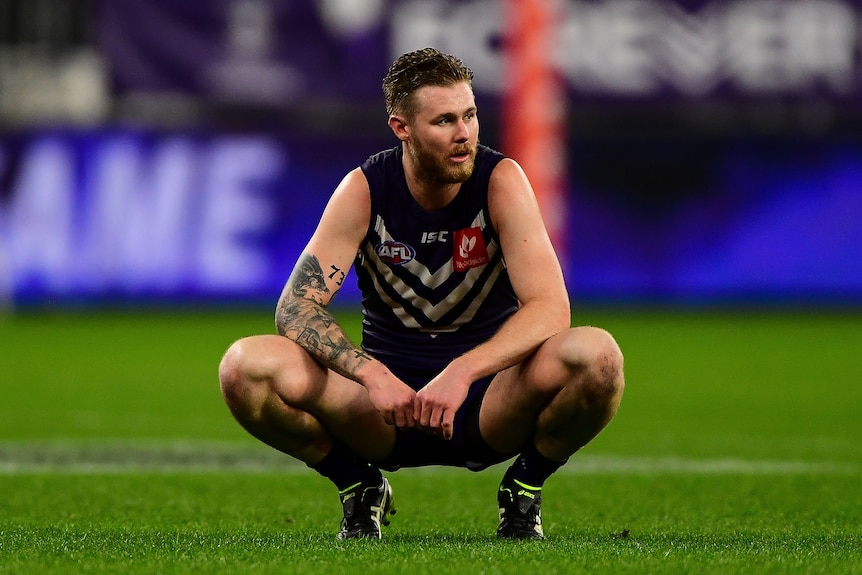 Cam McCarthy of Fremantle Dockers squats during an AFL game.