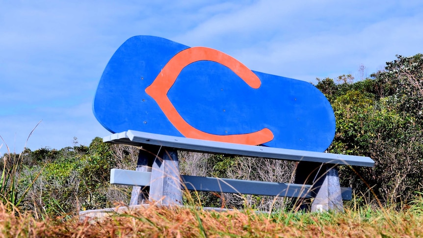 Orange and blue painted plywood, Big Thong seatback against blue sky.