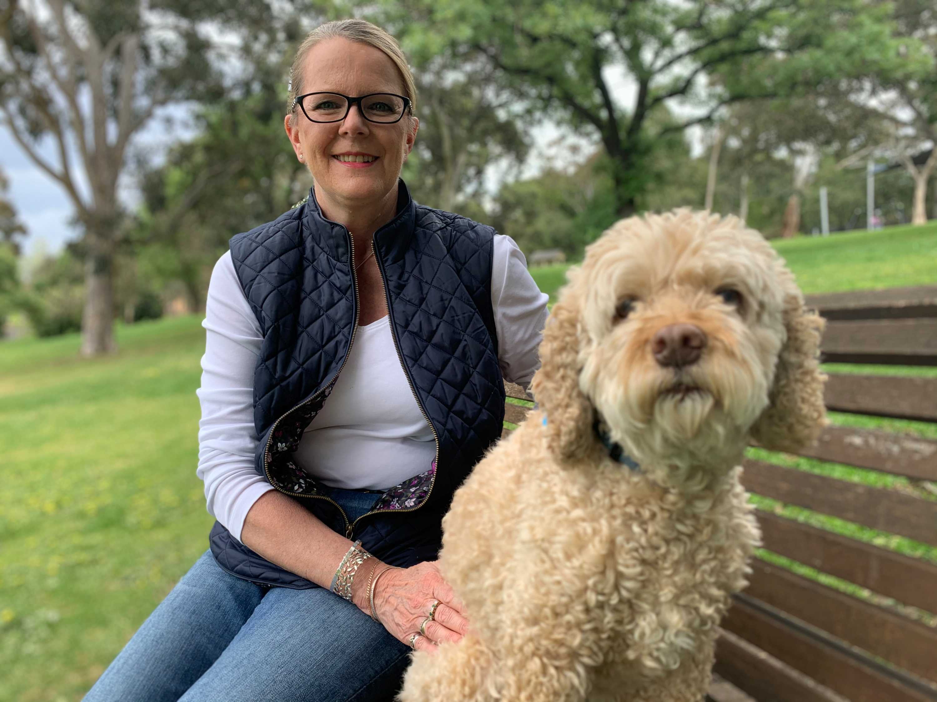Sheenagh Bottrell sits on a park bench with her dog.