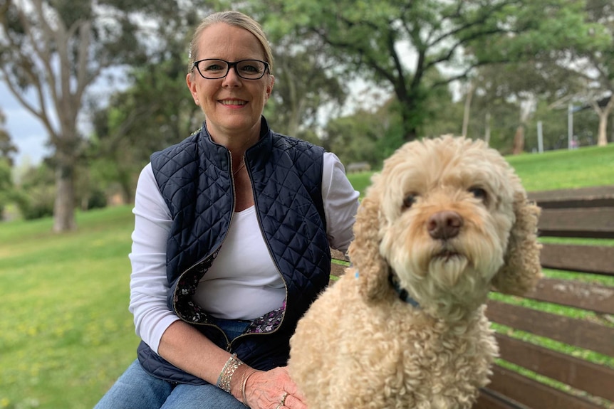 Sheenagh Bottrell sits on a park bench with her dog.