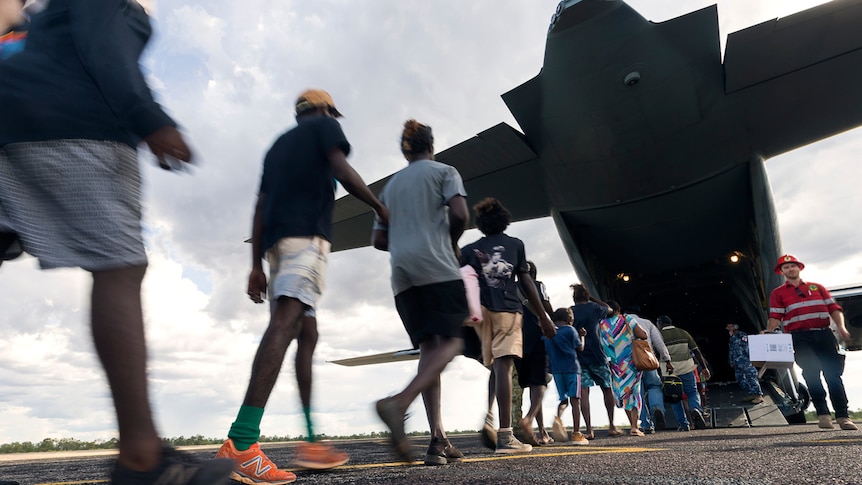 Evacuees boarding a plane to leave from Cyclone Trevor's path.