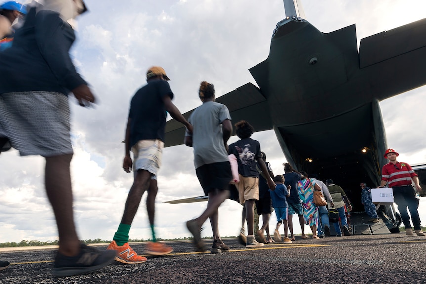 Evacuees boarding a plane to leave from Cyclone Trevor's path.