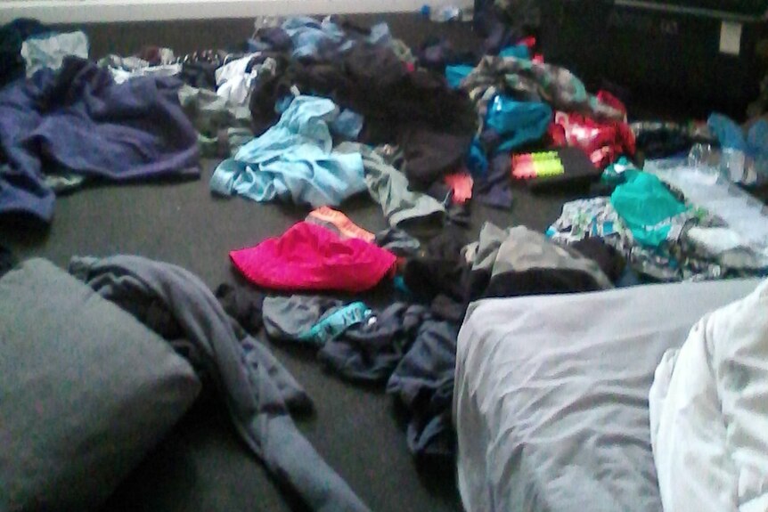 Photo of clothes on floor of bedroom at residential care accommodation in Hobart, taken by grandmother of autistic boy.