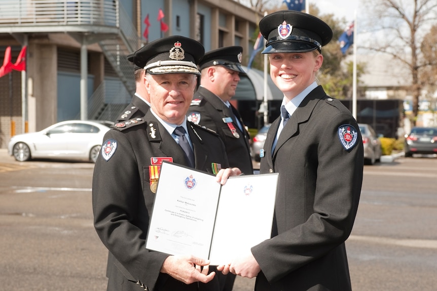 Young female fire officer with a senior fire officer at her graduation