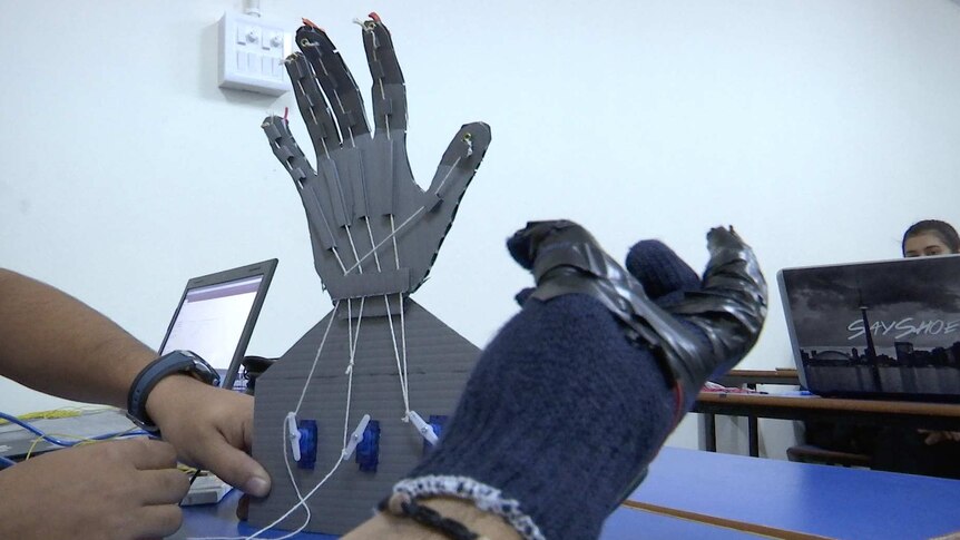 Mechatronics studies tinker with robotic hands, controlled by sensors wires into a glove so it moves as they flex their fingers.