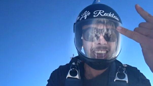 man skydiving and smiling to the camera
