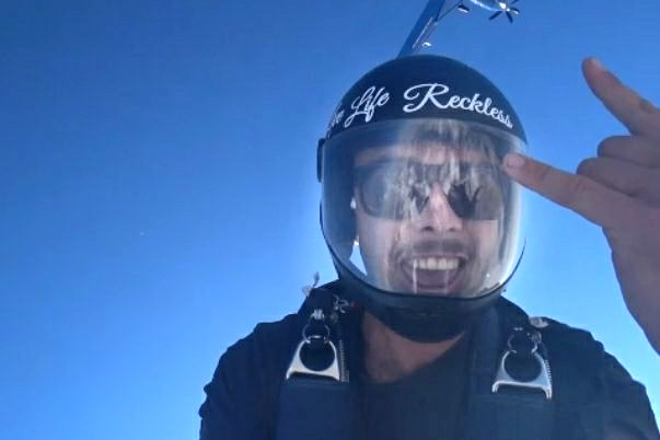 man skydiving and smiling to the camera