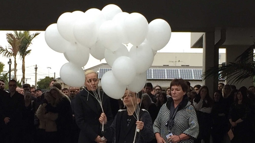 Two woman and a boy holding balloons