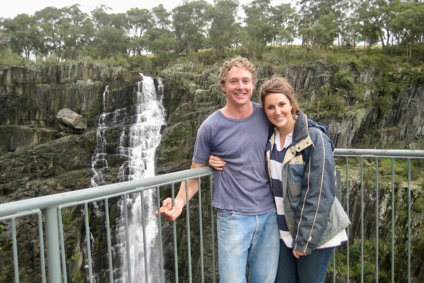 An old photo of a younger Alison Jones with her arm around her now husband Charlie in front of a waterfall