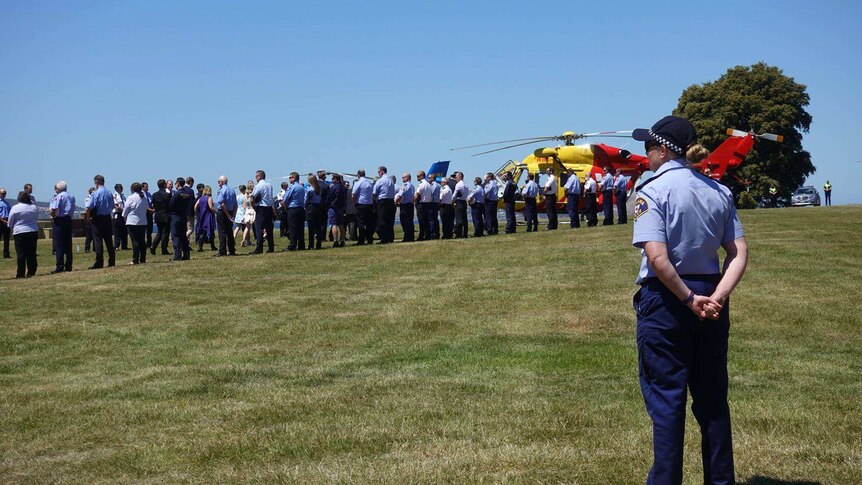 Police and emergency services line up at the funeral for pilot Roger Corbin in Hobart.