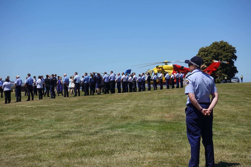 Police and emergency services line up at the funeral for pilot Roger Corbin in Hobart.