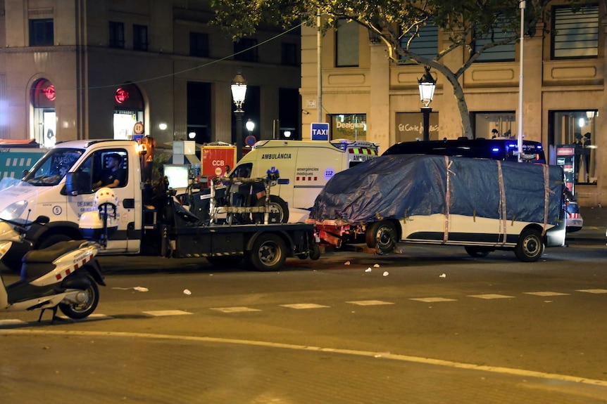 A covered white van is towed away.