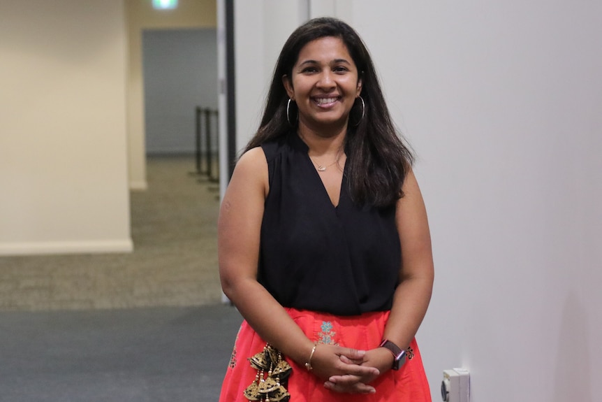 A mid-shot of  Prital Patel standing and smiling at the camera 