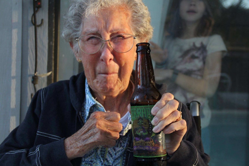 Norma drinking a beer on Ormond Beach in Florida.