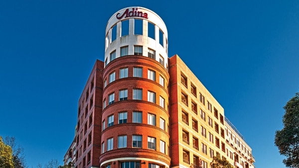 A hotel sign reading Adina outside a building