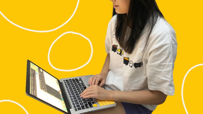 A woman sitting in front of a computer with a yellow background, in a story about racism at work and experiences of reporting.