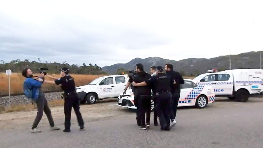 Police officers arrest French journalist Hugo Clement and a photographer at a protest outside Abbot Point coal terminal.