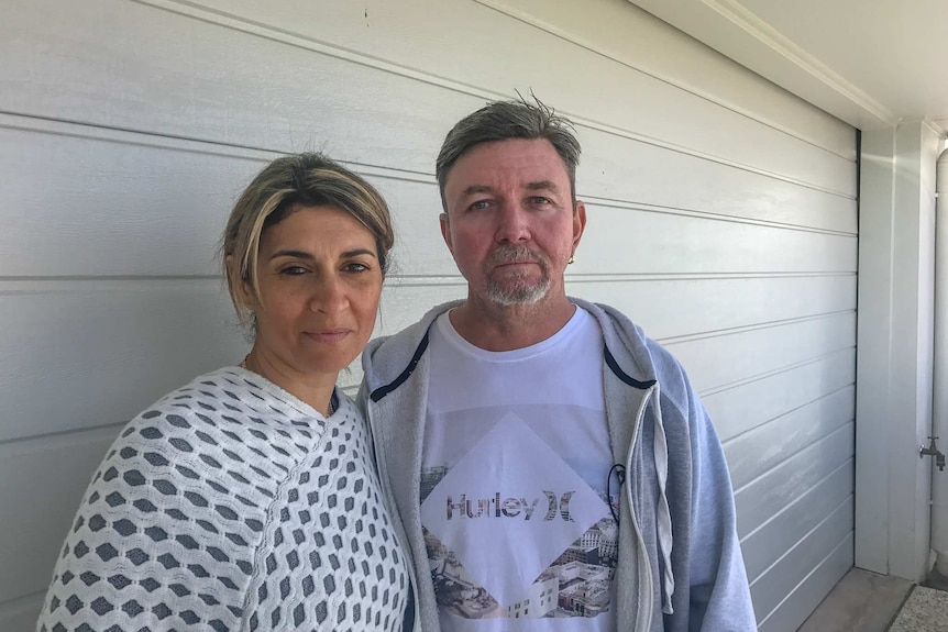 Michelle and Ian Tate stand in front of their carport.