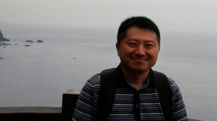 Chinese journalist Liu Hu smiles in a photo on the coat wearing a striped shirt