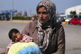 Syrian refugee holds her baby