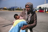 A Syrian refugee holds her baby in Greece
