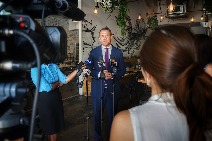 Chief Minister Michael Gunner wears a purple tie as he speaks to reporters