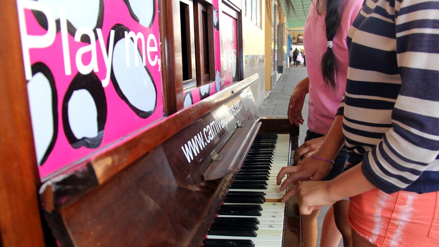 Two girls play a piano - one of many located throughout the Toowoomba CBD - on Margaret Street.
