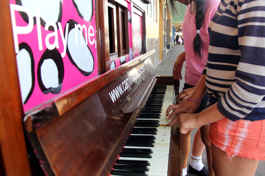 Two girls play a piano - one of many located throughout the Toowoomba CBD - on Margaret Street.