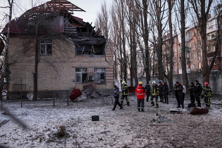 Authorities examine parts of a drone that hit a building in Kyiv.