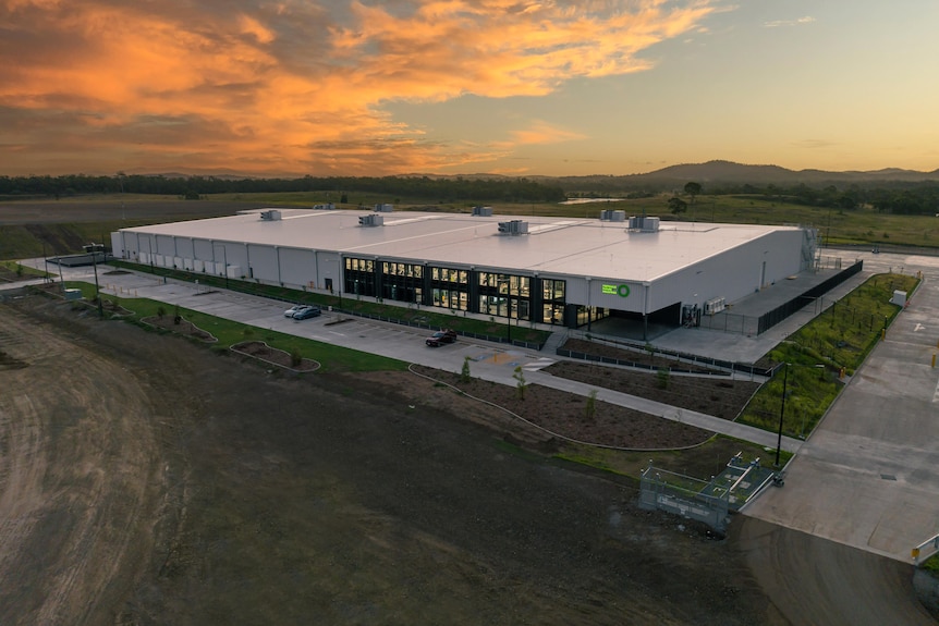 An aerial view of a large shed in a remote location at sundown.