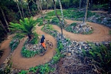 A cyclist navigates tight bends on a constructed mountain bike track.