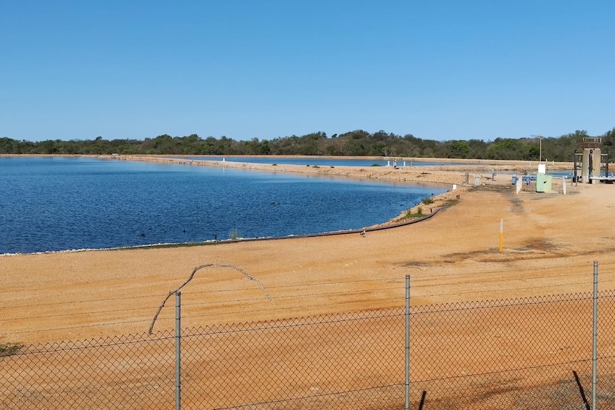 A wide shot of Broome wastewater treatment plant through a wire fence.