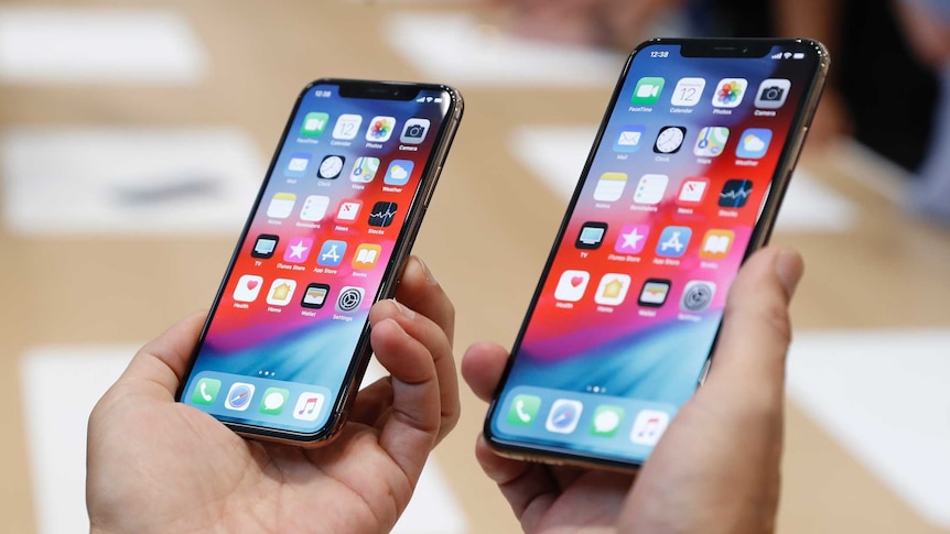 A man holds the newly released Apple iPhone XS and XS Max during a product demonstration.
