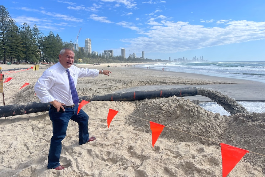 man standing next to pipe at beach