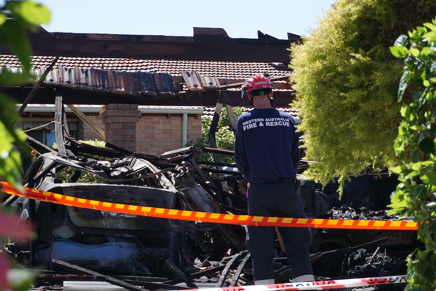 Police stand around the charred bodies of cars