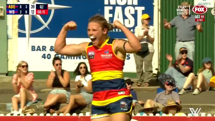 Adelaide Crows player Chloe Scheer flexes her muscles after a goal against the Western Bulldogs in the AFLW.