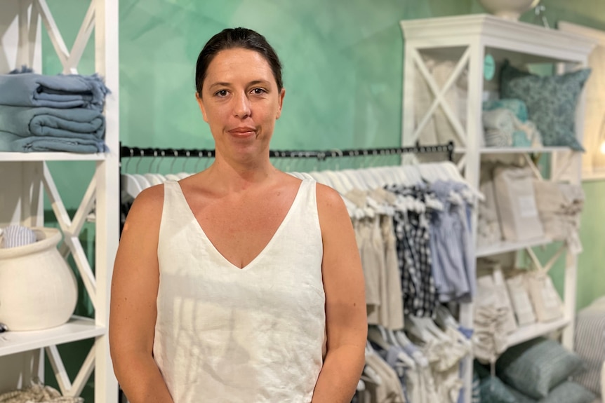 A woman stands in a clothing shop