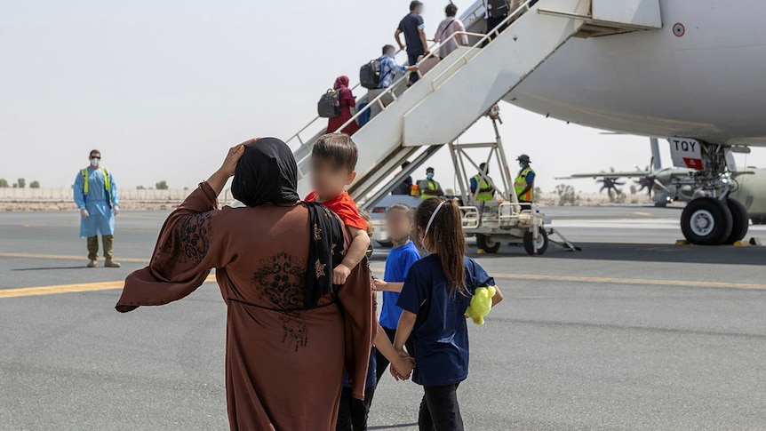 A mother and her children board a plane