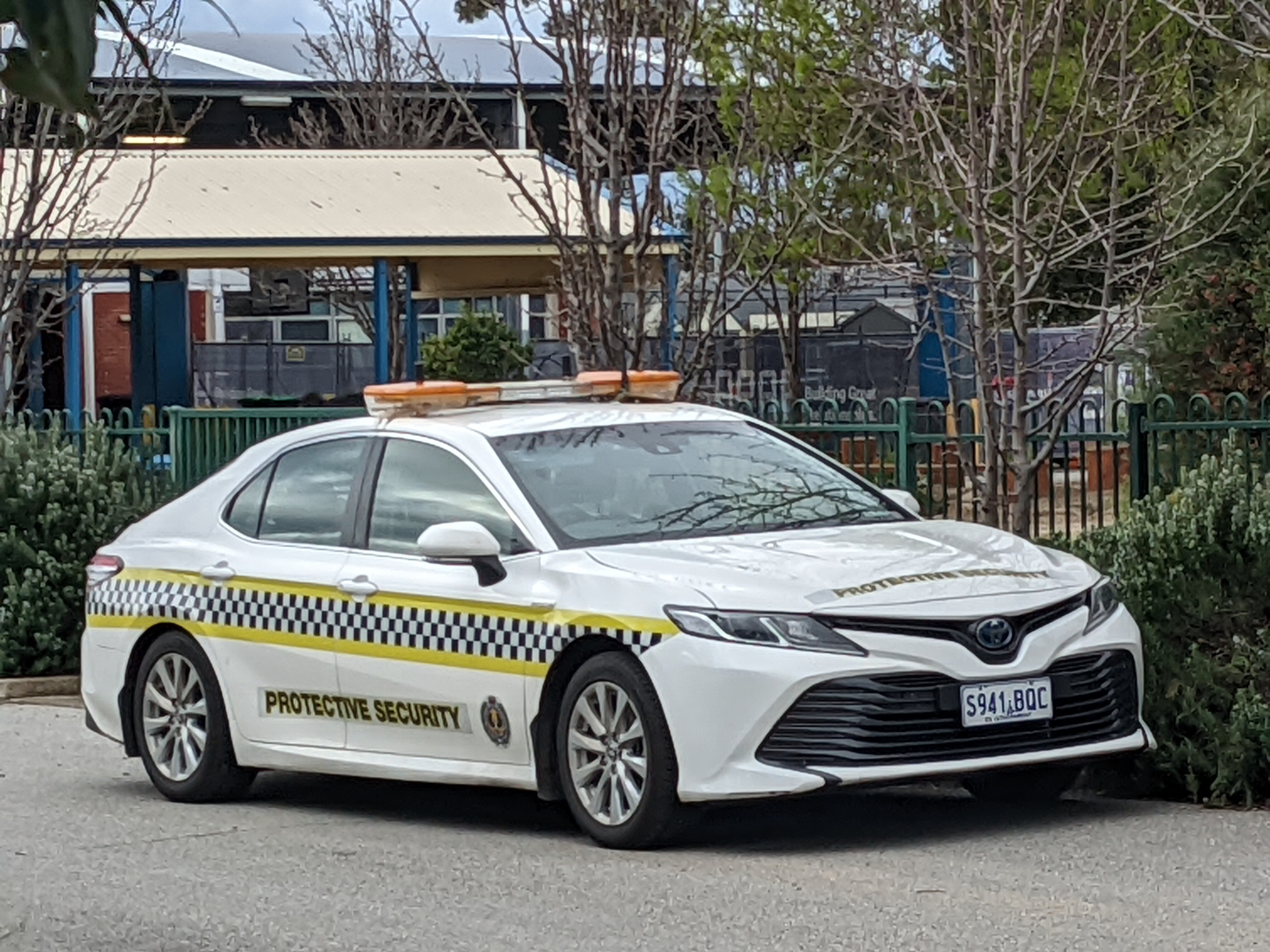 A protective security car outside school grounds